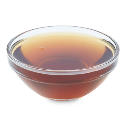 Small glass bowl filled with breakfast syrup, showcasing its rich amber color.