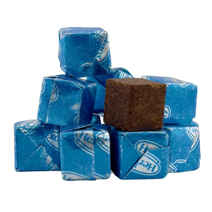 Stack of Herb-Ox vegetable bouillon cubes wrapped in blue foil, with one unwrapped cube placed on top.